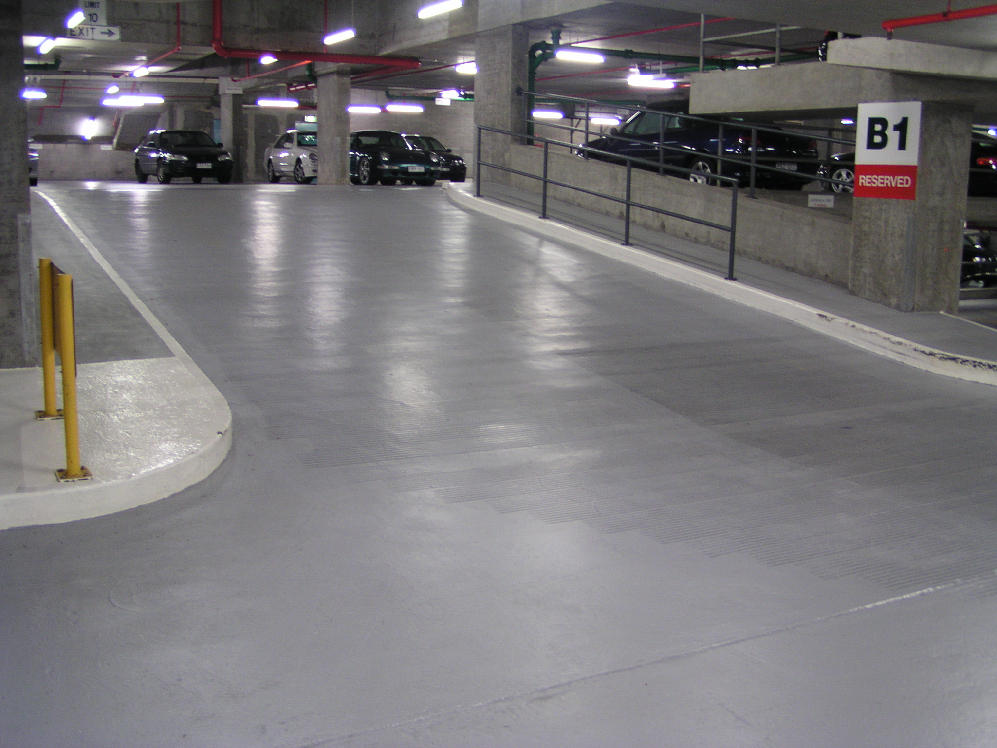 Aquepoxy® epoxy flooring across parking bays and traffic lanes in a high-rise car park.